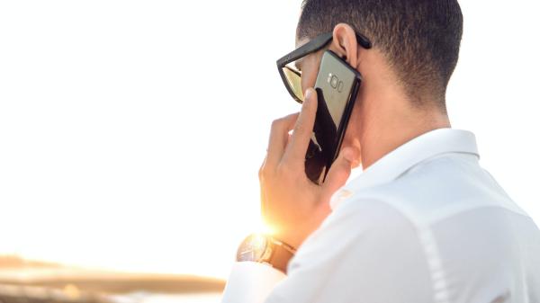 Man talks on the phone with back turned