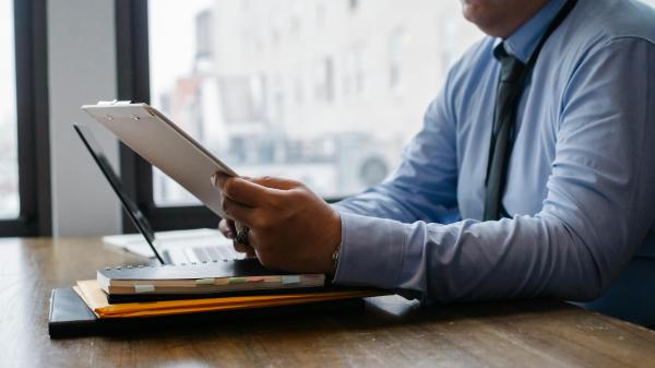 A man in business attire studies papers in front of him
