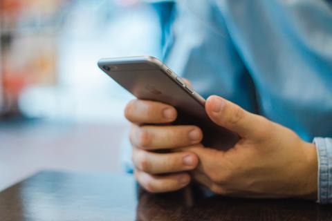 Photo of person looking at their mobile phone