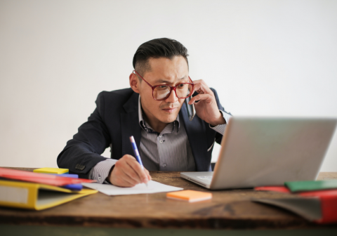 Man on phone working on laptop