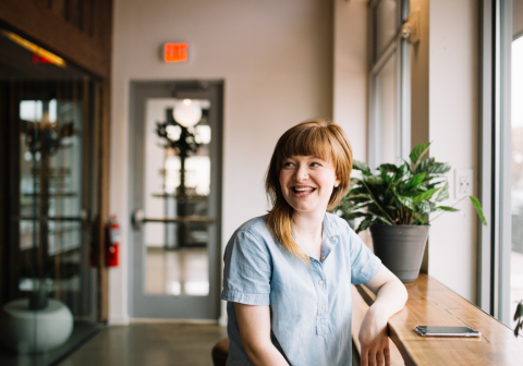 Woman smiling beside a window