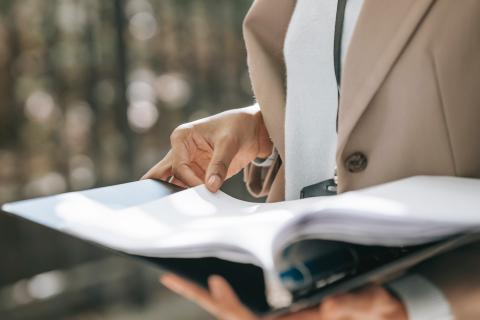 A folder of papers is held open 