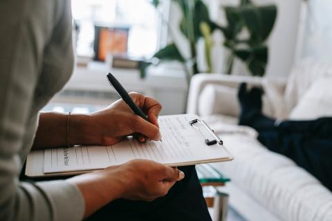 Person writes at a desk