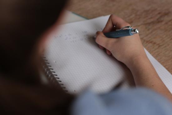 A person appears to journal with a black pen