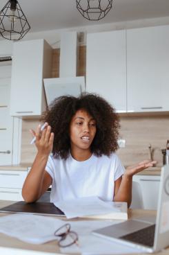 Woman in white t-shirt sits in kitchen